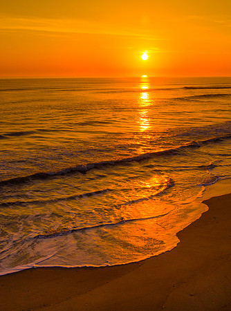 Calm seas and a golden glow at sunrise in Duck, NC