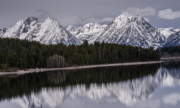Magnificant, reflecitve view of the Grand Tetons with Jackson Lake in the foreground