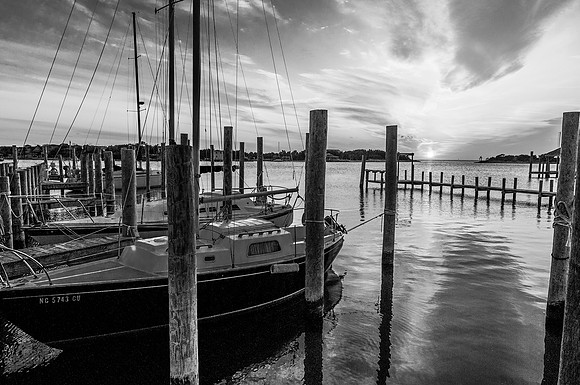 The sun sets over a tranquil Silver Lake harbor, Ocracoke, NC (B&W)